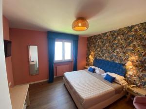 a bedroom with a large bed with blue pillows at Hotel Villa Lubrense Sorrento in Massa Lubrense