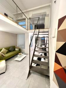 a staircase in a living room with a green couch at Excelente loft en Trafalgar in Madrid