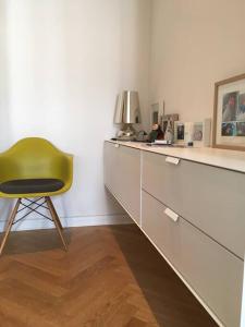 einem grünen Stuhl neben einer Kommode in der Unterkunft Tolle Designer Wohnung in der Südvorstadt in Leipzig