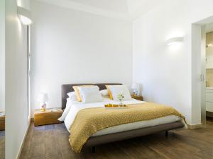 a bedroom with a large bed with a yellow blanket at Villa SanLorenzo Beach in Marzamemi