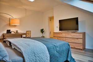 Dormitorio con cama y tocador con TV en Wohnung im Herzen Bochums (1 km zum Hauptbahnhof) en Bochum