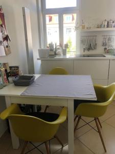 eine Küche mit einem Tisch und 2 gelben Stühlen in der Unterkunft Tolle Designer Wohnung in der Südvorstadt in Leipzig