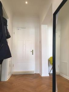 Cette chambre dispose d'une porte blanche et d'une chaise jaune. dans l'établissement Tolle Designer Wohnung in der Südvorstadt, à Leipzig