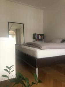 ein Schlafzimmer mit einem Bett in einem Zimmer mit einer Pflanze in der Unterkunft Tolle Designer Wohnung in der Südvorstadt in Leipzig