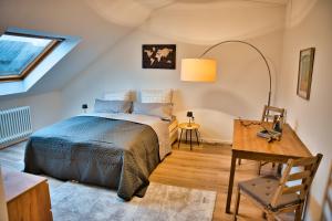 a bedroom with a bed and a desk and a window at Wohnung im Herzen Bochums (1 km zum Hauptbahnhof) in Bochum
