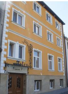 Un edificio amarillo con un cartel delante. en Aparthotel Adler, en Cracovia