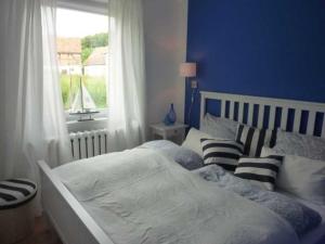 a blue bedroom with two beds and a window at Ferienwohnung "Kleine Sandburg" in Heiligendamm