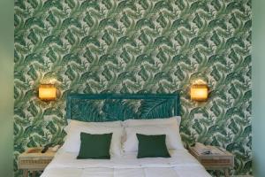 a bedroom with a bed with two green pillows at Hotel Villa Lubrense Sorrento in Massa Lubrense