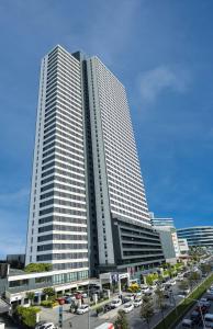 a tall building with cars parked in a parking lot at Fraser Place Antasya Istanbul in Istanbul