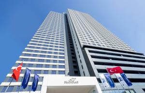a tall building with flags in front of it at Fraser Place Antasya Istanbul in Istanbul