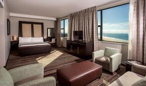 a hotel room with a bed and a large window at Garden Court Kings Beach in Port Elizabeth