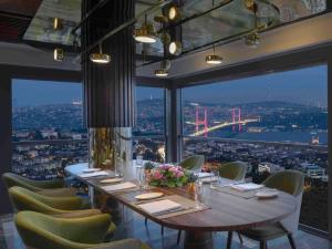a long table in a room with a view of the golden gate bridge at Mövenpick Hotel Istanbul Bosphorus in Istanbul