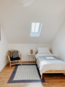 a bedroom with a bed and a chair and a window at East Street Beach House - luxury living by the sea in Ryde