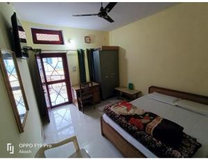 Gujrat Bhawan, Phata في Phata: غرفة نوم بسرير ومروحة سقف