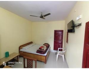 una camera con un letto e una sedia di Gujrat Bhawan, Phata a Phata