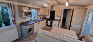 a small kitchen with a stove and a microwave at Holiday Caravan at Beauport in Hastings