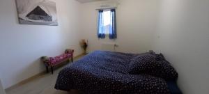 a bedroom with a blue bed and a window at les campanules in Bourg-Saint-Maurice
