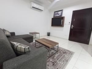 uma sala de estar com um sofá e uma televisão em شقق مفروشة شهري وسنوي em Obhor