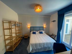 a bedroom with a bed and a book shelf at Hotel Villa Lubrense Sorrento in Massa Lubrense