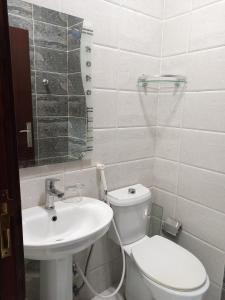 a bathroom with a white toilet and a sink at شقق مفروشة شهري وسنوي in Obhor