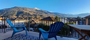 two blue chairs sitting on a balcony with a table at les campanules in Bourg-Saint-Maurice