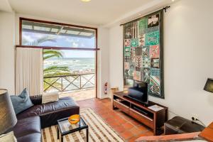 a living room with a couch and a flat screen tv at Camps Bay Terrace Palm Suite in Cape Town