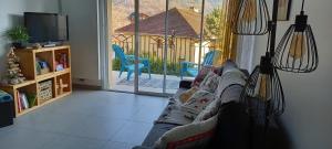 a living room with a couch and a view of a porch at les campanules in Bourg-Saint-Maurice