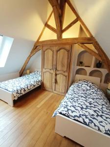 1 dormitorio con 2 camas y suelo de madera en Gîte avec vue sur l'Indre en Artannes-sur-Indre