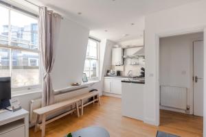 Apartamento blanco con banco y cocina en So Glamorous Pad - Fitzrovia - by Frankie Says, en Londres