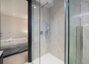 - une douche avec une porte en verre dans la chambre dans l'établissement Luxury 3 Bedroom Flat in Maida Vale, à Londres