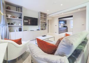 a living room with white chairs and a couch at Luxury 3 Bedroom Flat in Maida Vale in London