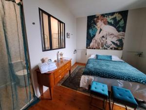 sypialnia z łóżkiem, komodą i lustrem w obiekcie au milieu coule la Garonne 