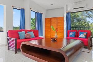 a living room with red chairs and a wooden table at Playa Negra Peaceful & Luxury Beach Dream Penthouse in Playa Negra