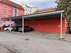 eine große rote Garage mit Autos in der Garage in der Unterkunft Apartmán AB kryté parkování zdarma in Budweis