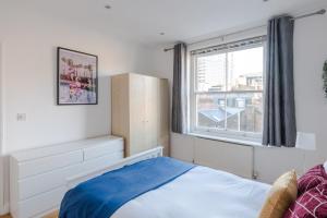 1 dormitorio con cama y ventana en So Glamorous Pad - Fitzrovia - by Frankie Says, en Londres