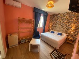 a bedroom with a bed and a wall with a fan at Hotel Villa Lubrense Sorrento in Massa Lubrense