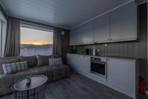 a living room with a couch and a table at Aurora Borealis Observatory in Silsand