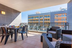 balcón con mesas y sillas y vistas a un edificio en Elegant 2 BDR Flat W/ Rooftop Pool by LovelyStay, en Olhão