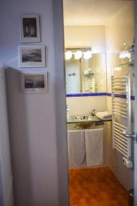 een badkamer met een wastafel, een spiegel en handdoeken bij la casita de invitados in Los Baños