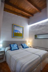 1 dormitorio con 1 cama grande con almohadas azules en la casita de invitados, en Los Baños