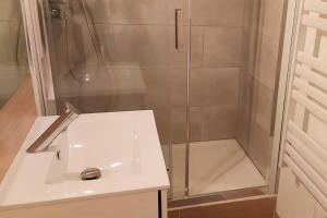 La salle de bains est pourvue d'une douche et d'un lavabo blanc. dans l'établissement Zénith - Cartoucherie - Purpan, à Toulouse