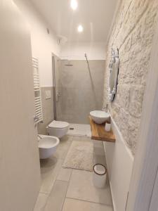 bagno con 2 servizi igienici, lavandino e doccia di La Relais del Trullo a Putignano