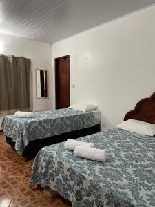 two beds in a hotel room with towels on them at Pousada Recanto dos Sonhos in Alto Paraíso de Goiás