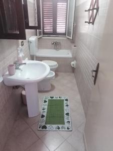 a white bathroom with a sink and a toilet at Nuovo AliRu in Campofelice di Roccella