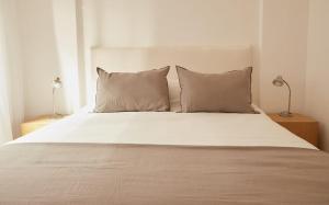a white bed with two pillows on it at Hestia At Patio Bullrich 1bdr Apartment in Buenos Aires