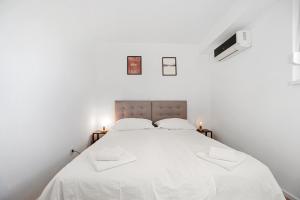 a white bedroom with a large bed with white sheets at Prime View Apartments Blanca and Lena in Zagreb