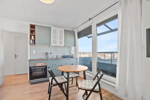 a kitchen with a table and chairs and a large window at Prime View Apartments Blanca and Lena in Zagreb