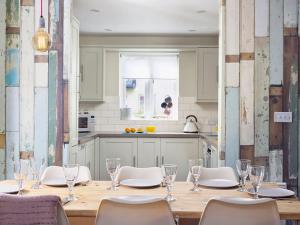 a dining room with a table and chairs and a kitchen at Oakleigh Cottage - lakes, spa, pools, sports, nature reserve in Somerford Keynes