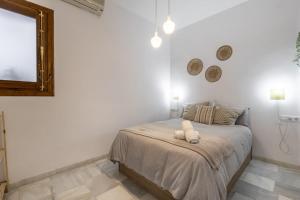 una camera da letto con un letto e uno specchio a parete di Luxury Suite de Trabuco a Granada