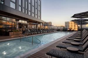 a swimming pool with chairs and a building at Hotel Fraye Nashville, Curio Collection By Hilton in Nashville